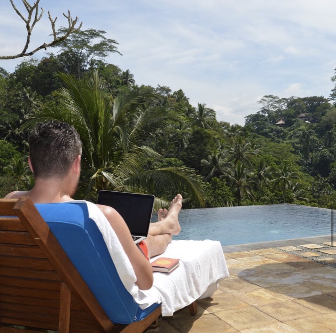 Nick working on a laptop by a pool in Bali